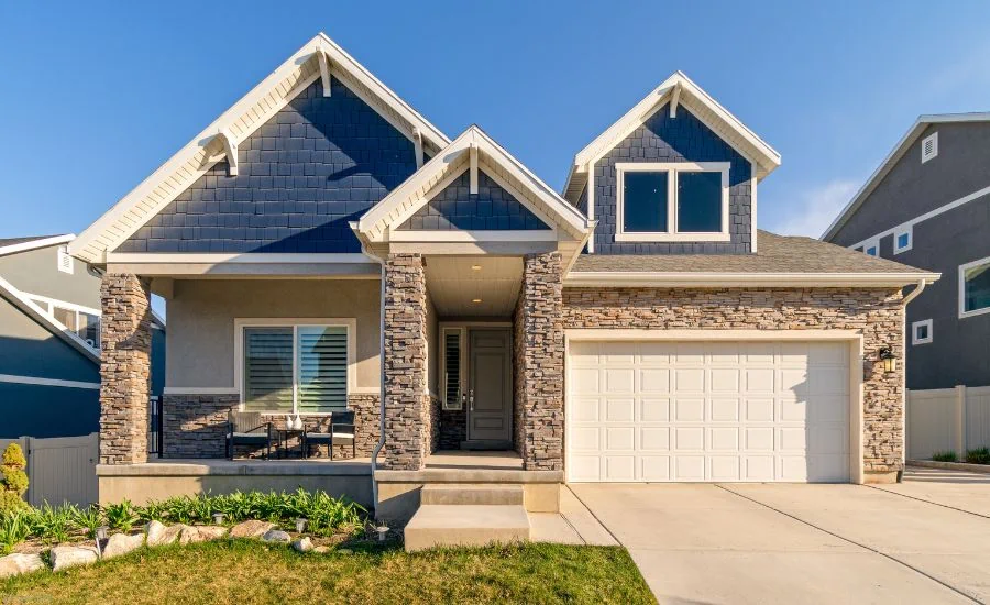 Photo of the front of a stone and siding house