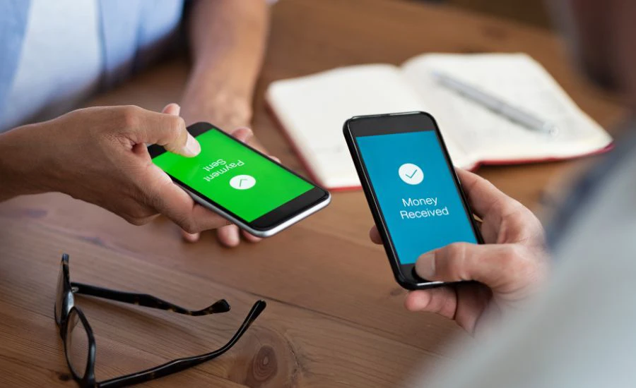 Two people holding phones sending and receiving money